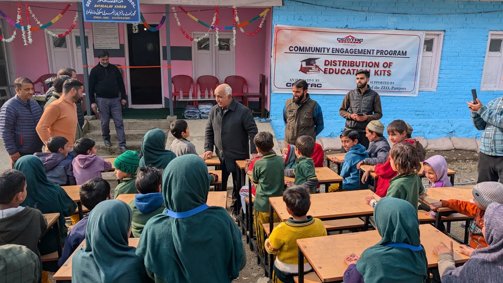 A guest speaking with students at their desks