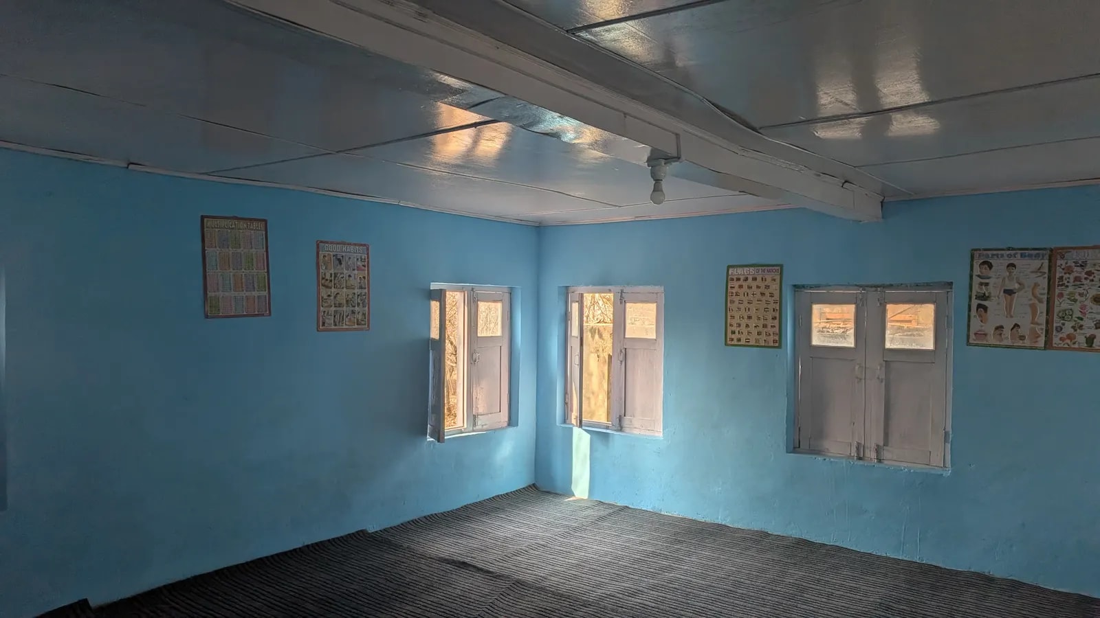 A repainted classroom with new matting and educational charts