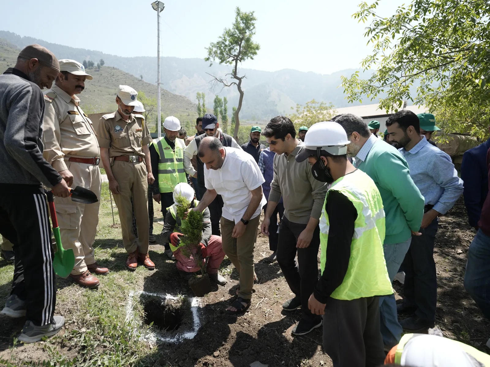 Officials and plant staff planting a sapling at the plant